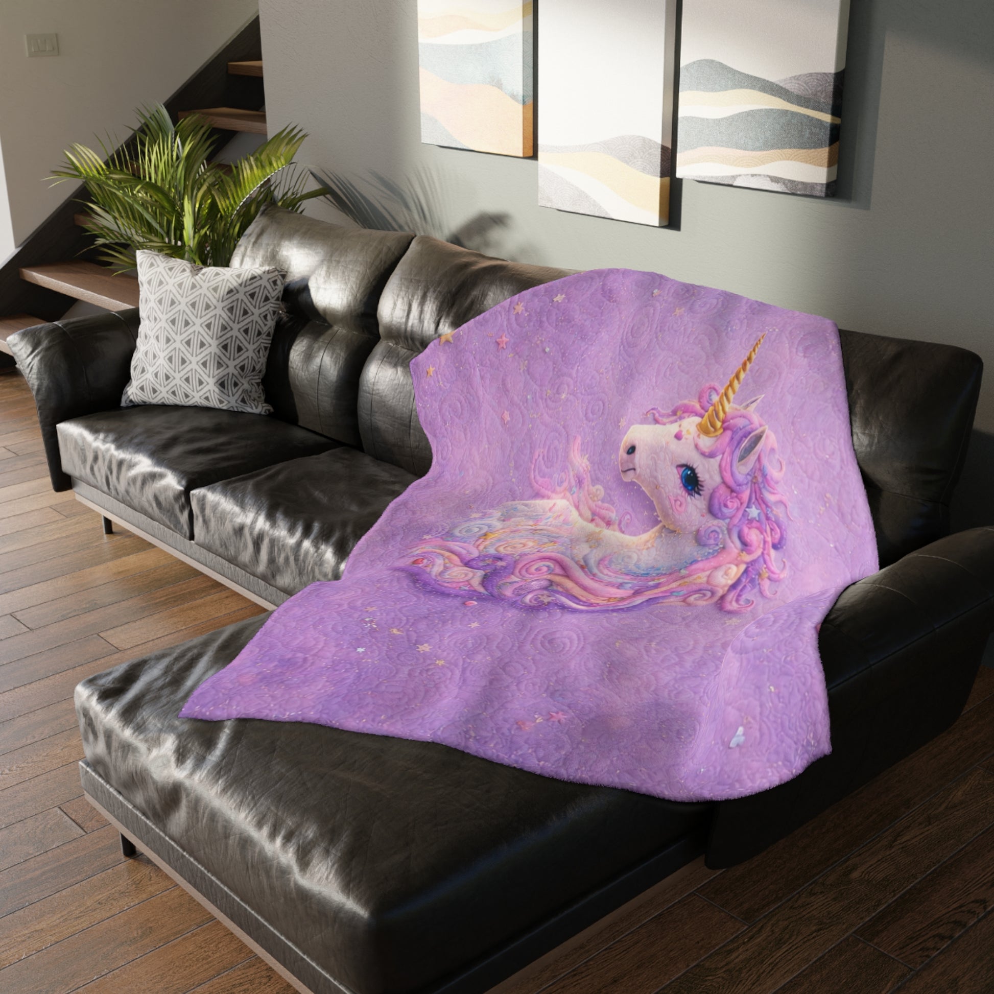 Purple unicorn blanket on a black couch in a living room setting