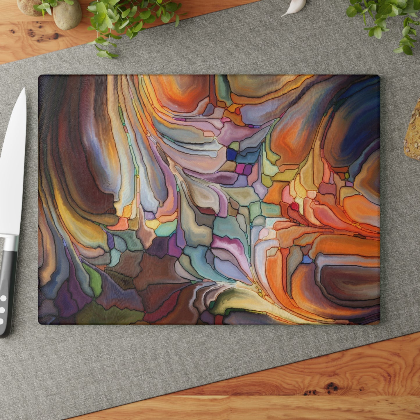 Colorful abstract design on a cutting board with a knife on a gray surface.