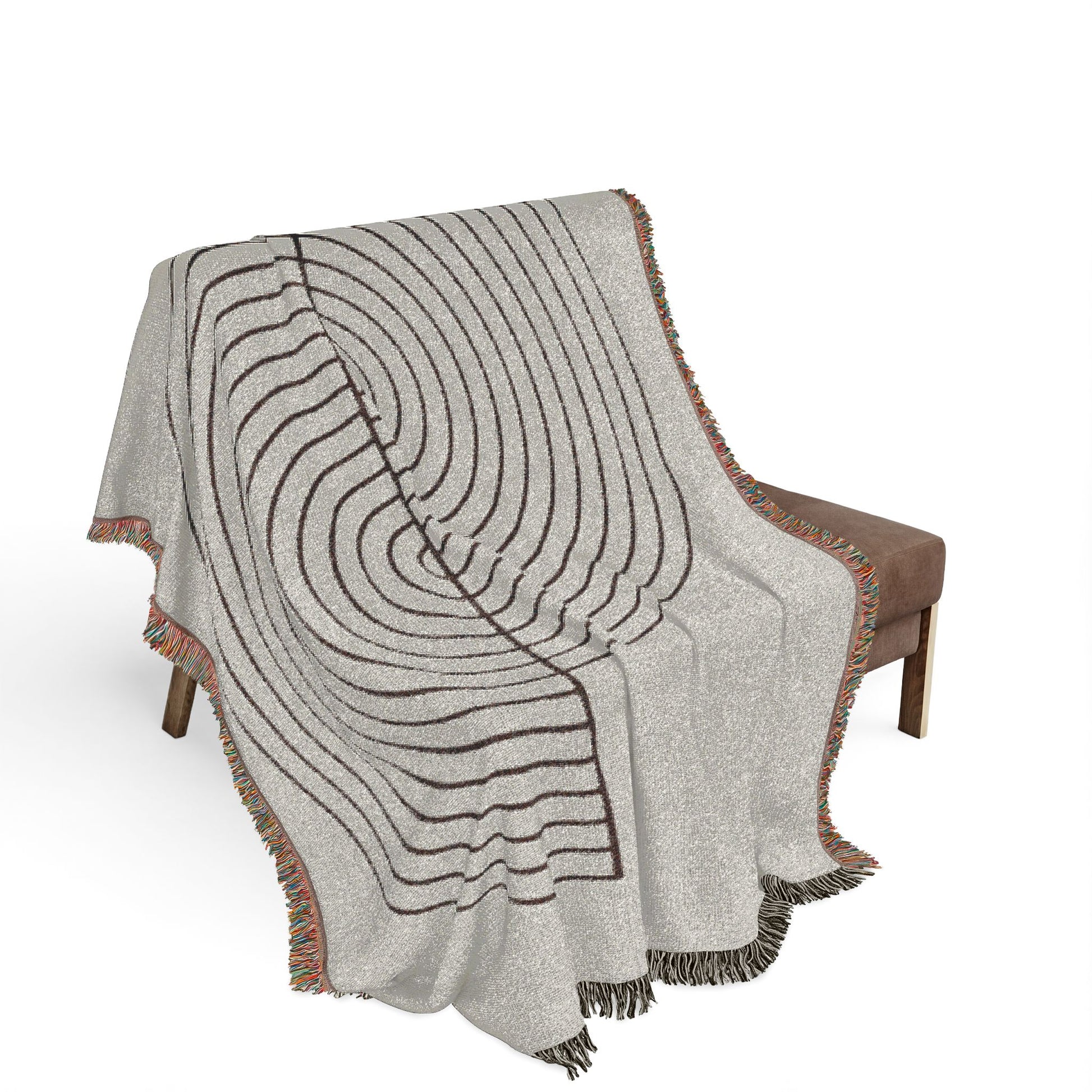 Gray patterned throw blanket draped over a brown chair on a white background