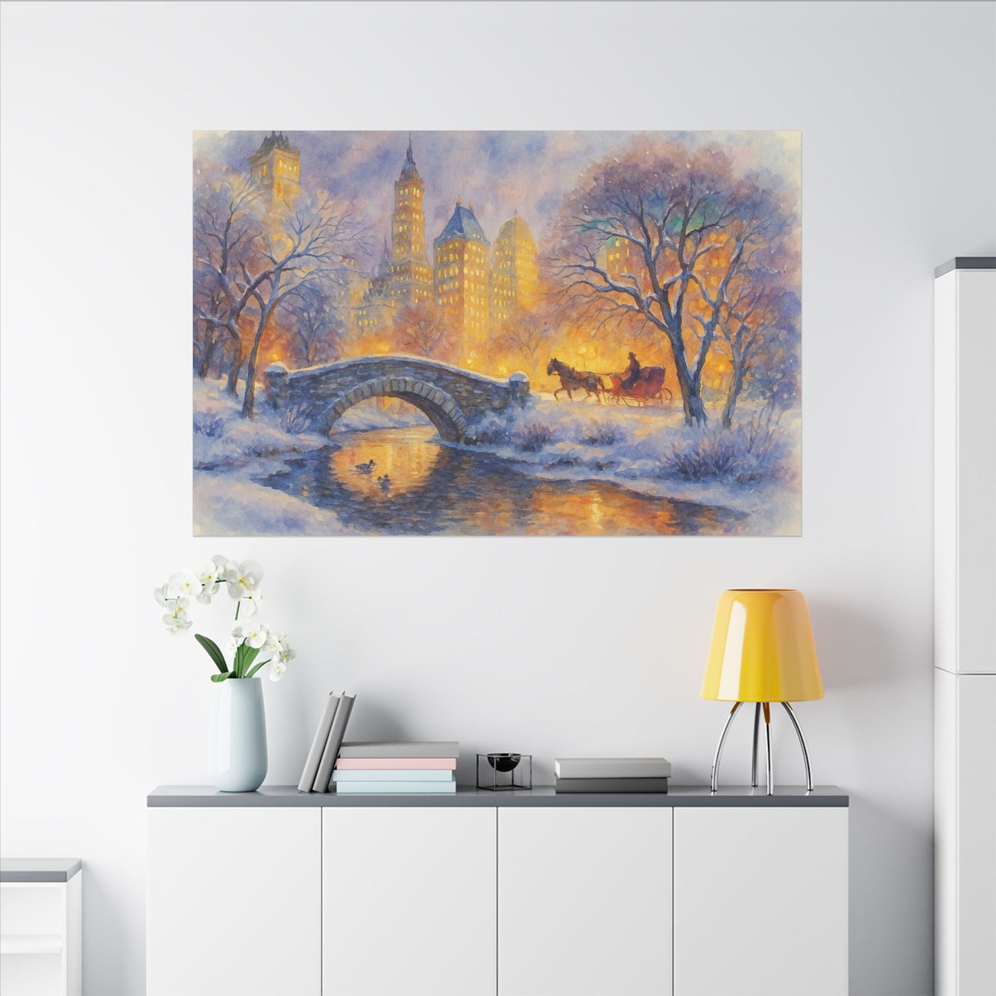 Winter scene with a bridge and horse-drawn carriage on a wall above a white cabinet.