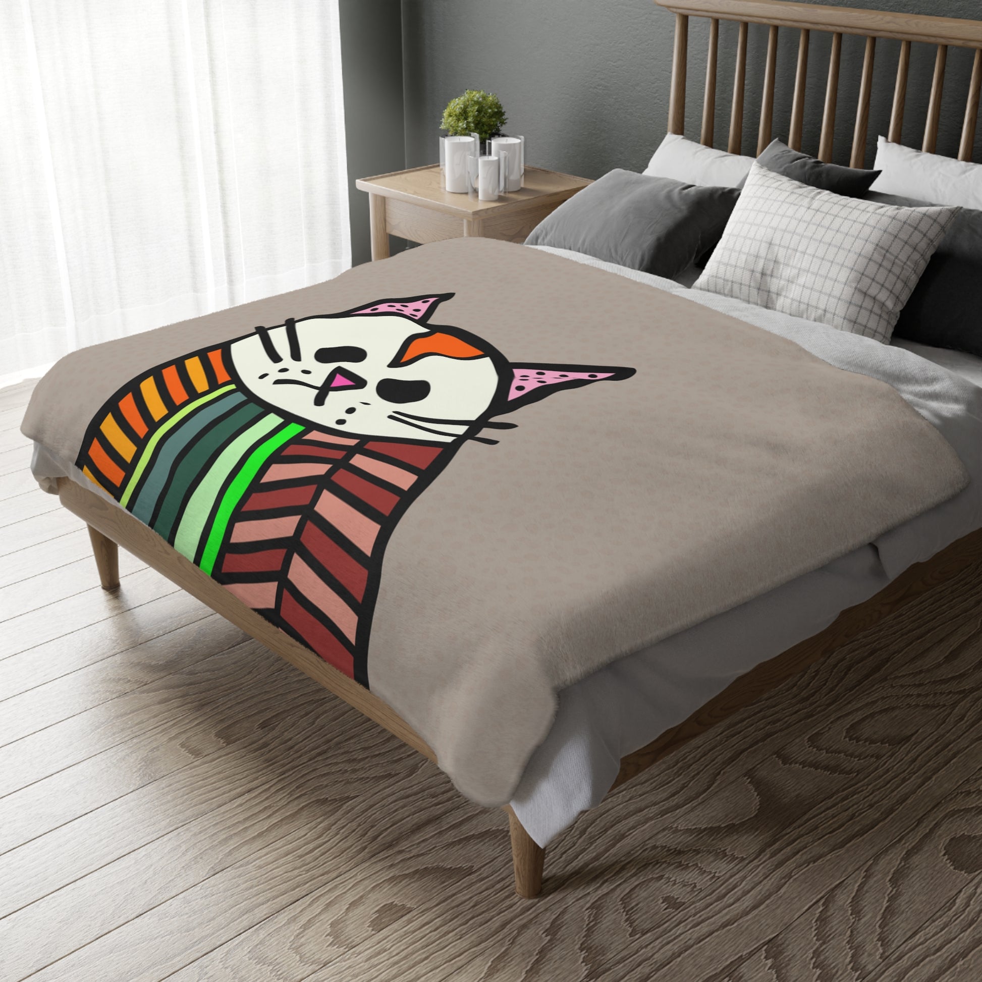 Bed with a colorful cat design blanket in a bedroom setting