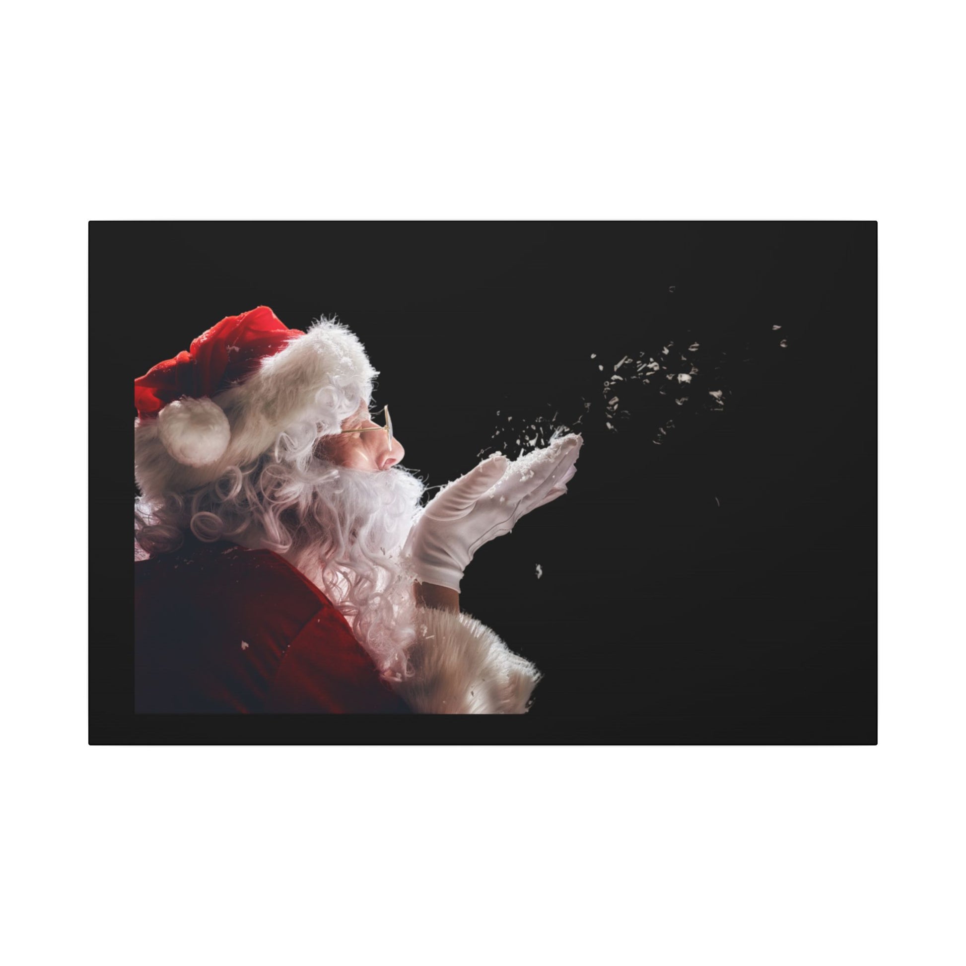 Santa Claus blowing snowflakes against a black background