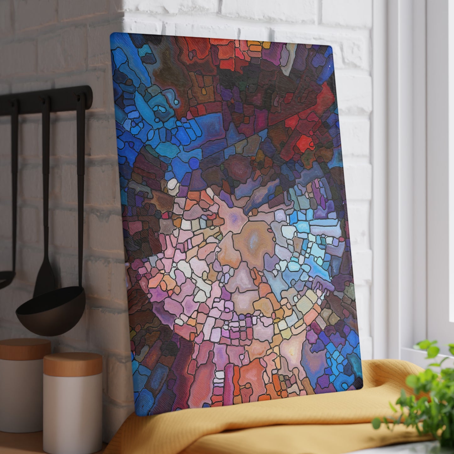 Colorful abstract wall art in a kitchen setting with utensils and a plant.