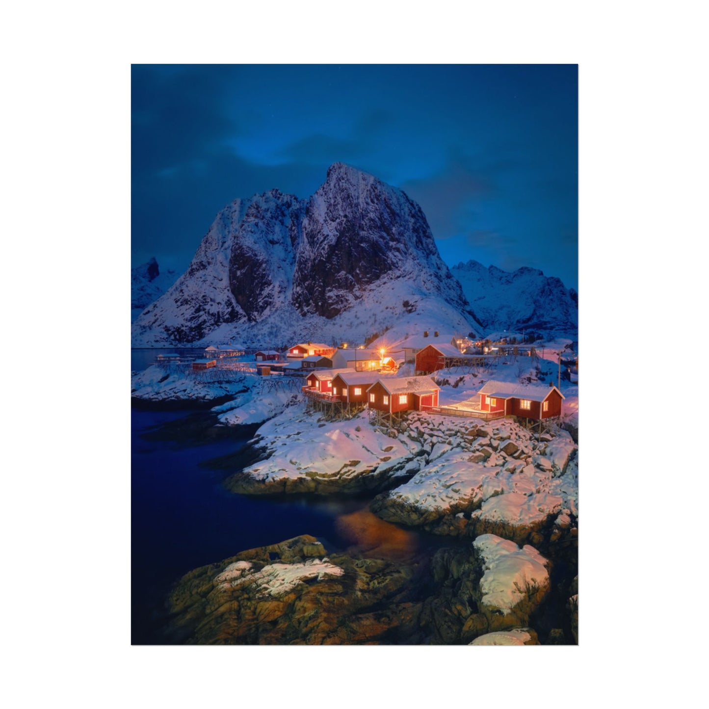 Snowy mountain landscape with illuminated buildings at night