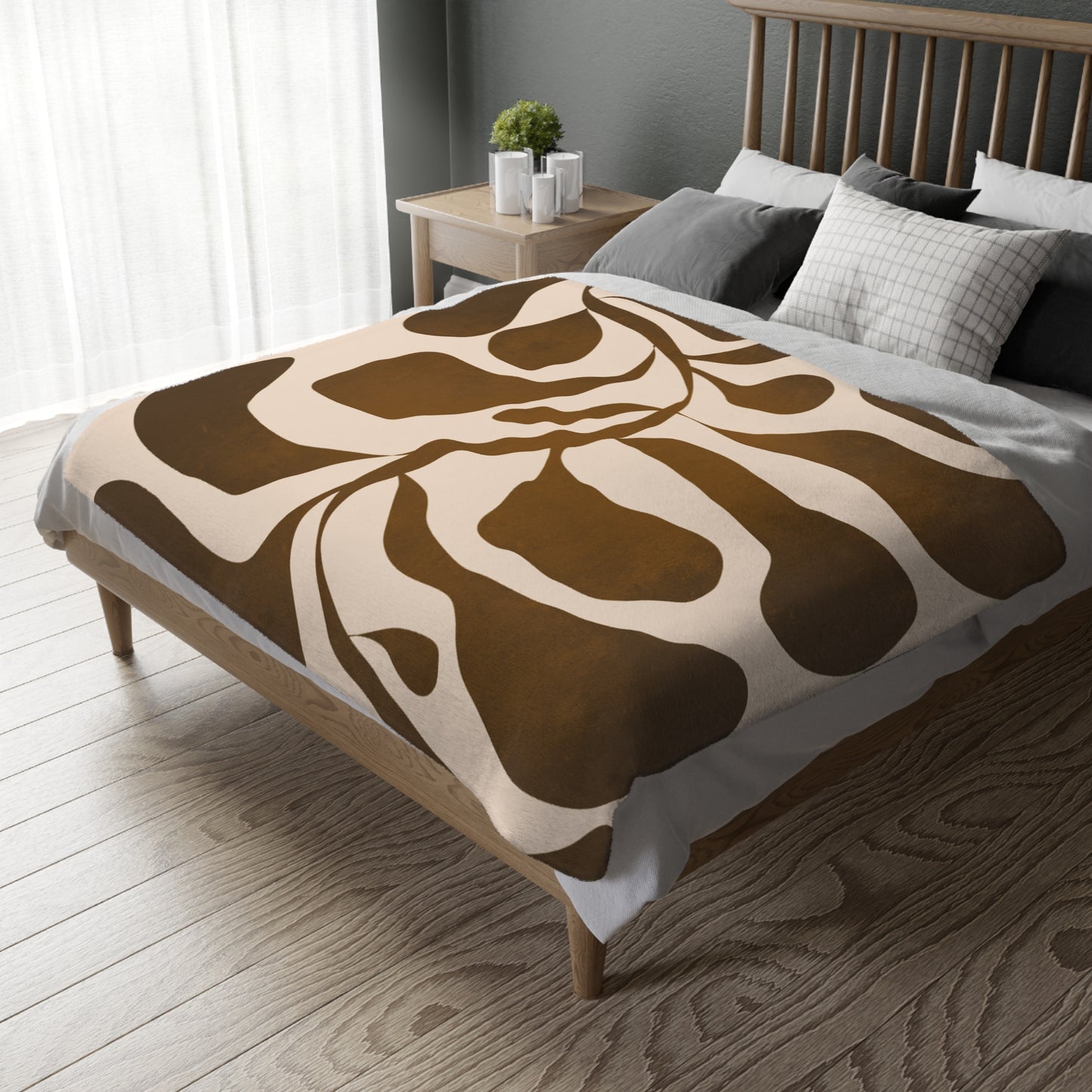 Bed with a brown and beige patterned blanket in a bedroom setting