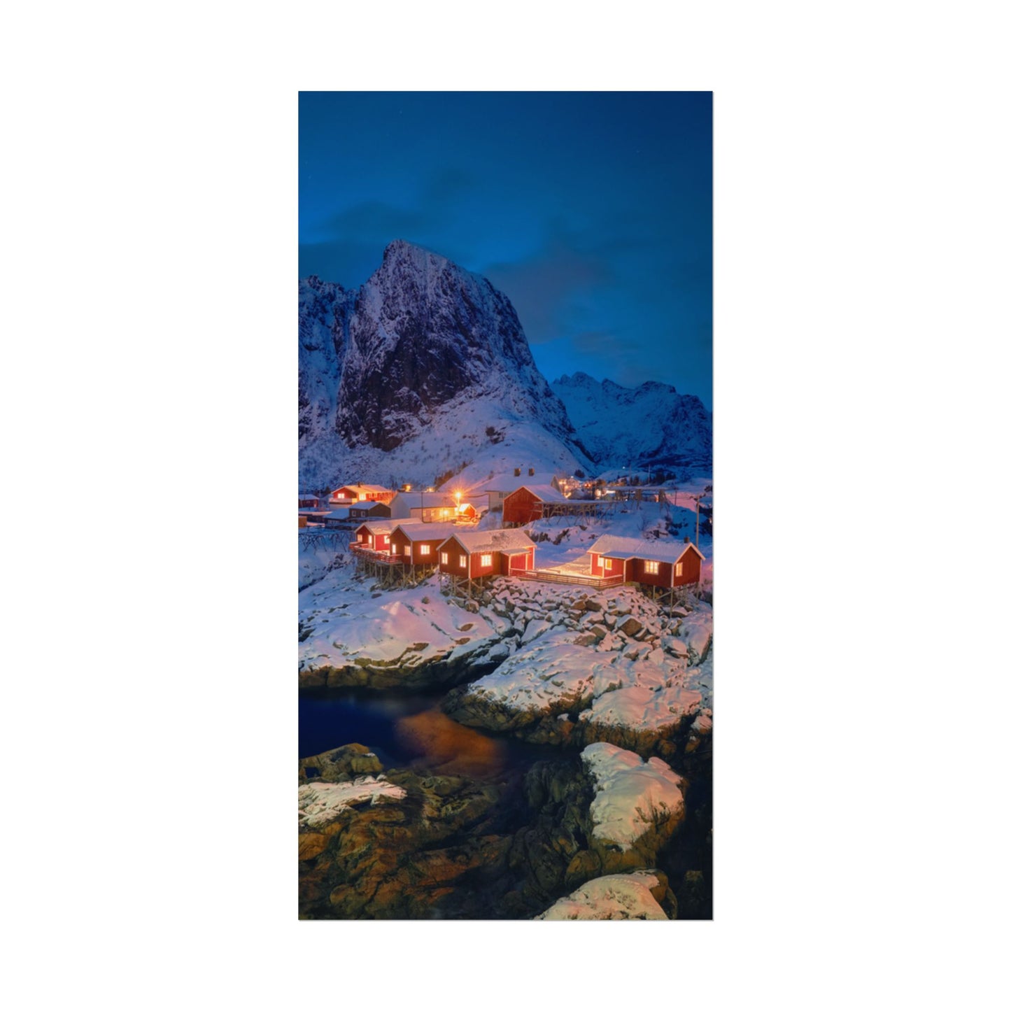 Snowy mountain landscape with illuminated cabins at dusk