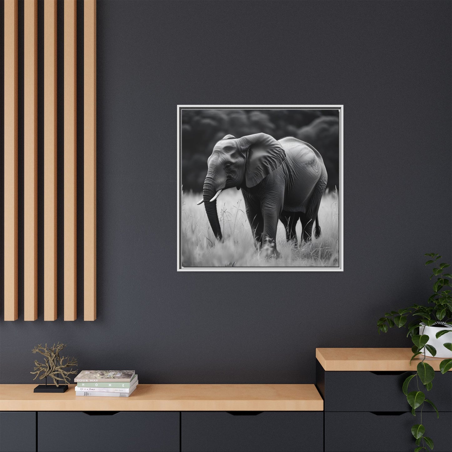 Framed black and white elephant print on a dark wall with wooden shelves below.