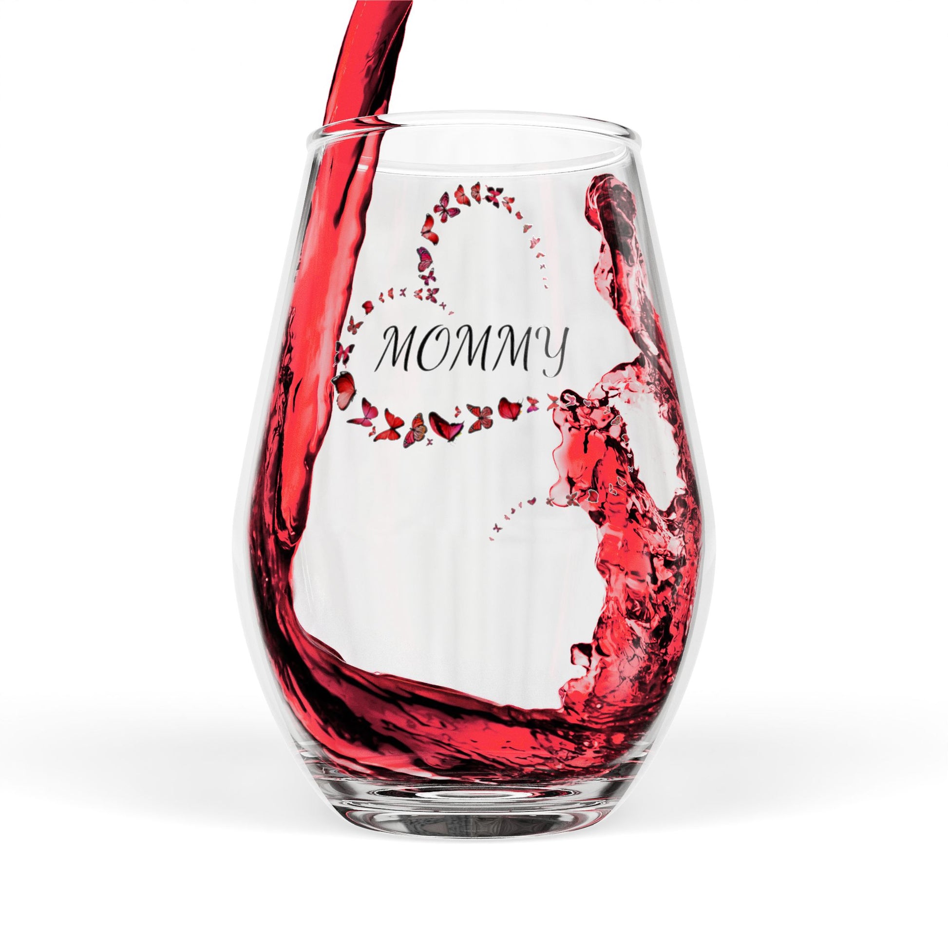 Clear wine glass with 'Mommy' engraving being filled with red wine on a white background