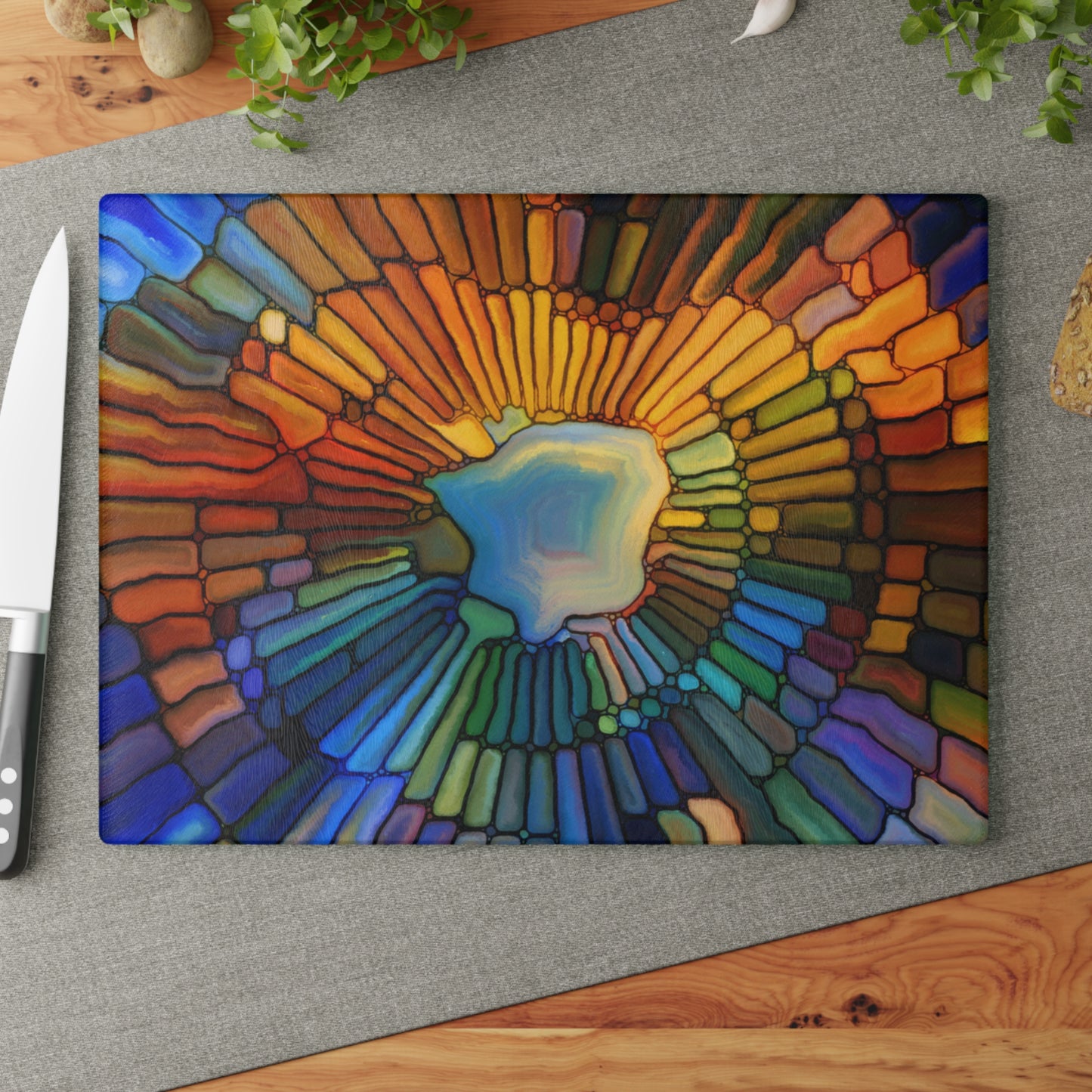Colorful abstract design on a cutting board with a knife on a wooden surface.