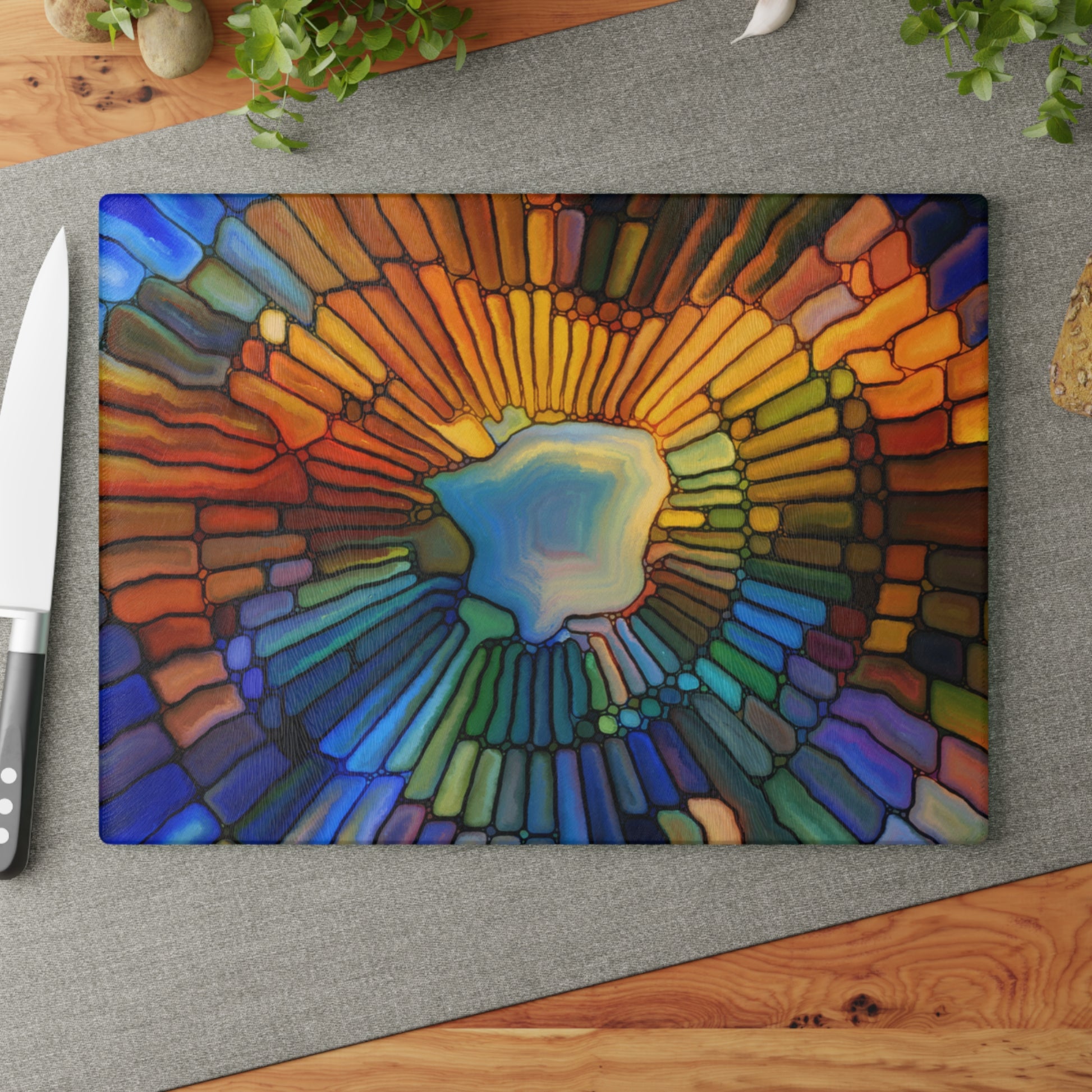 Colorful abstract design on a cutting board with a knife on a wooden surface.