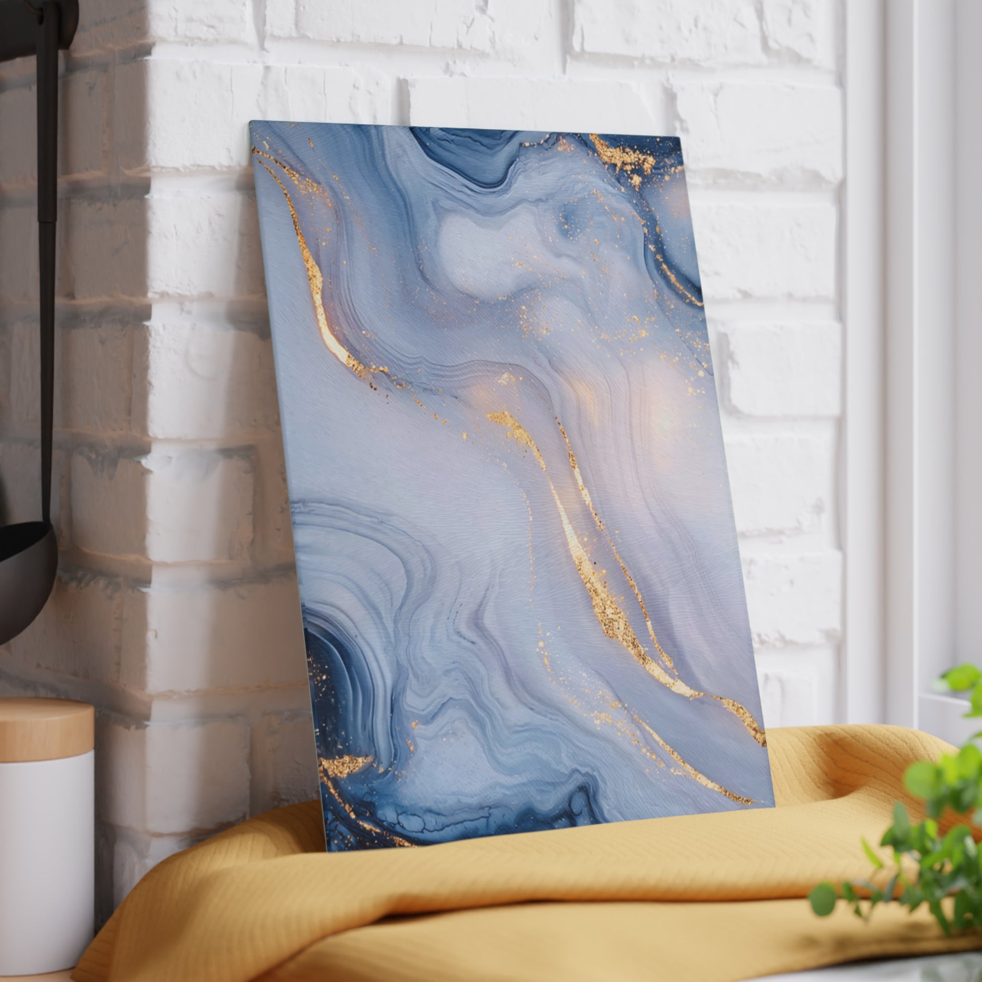 Abstract art piece with blue and gold patterns on a white brick wall.