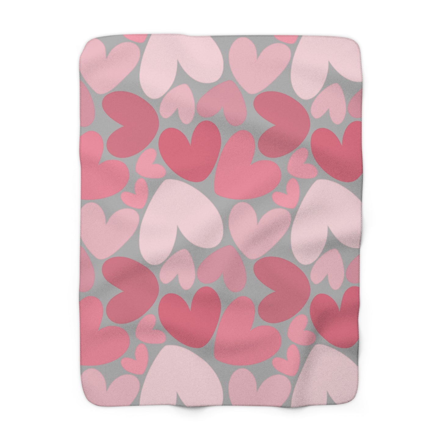 Fleece blanket with pink and red heart pattern on gray background