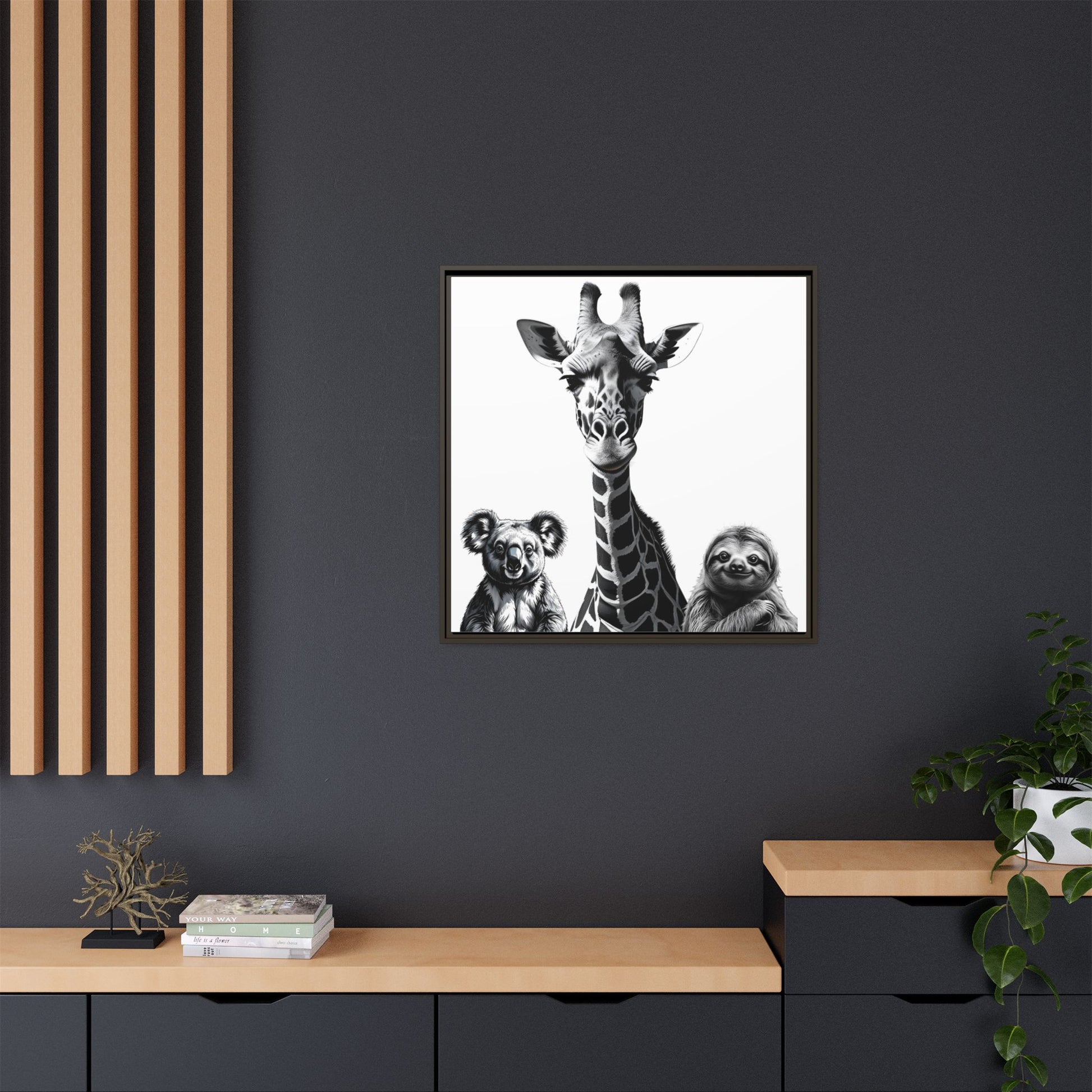 Framed artwork of a giraffe with two sloths on a dark wall above a wooden shelf.