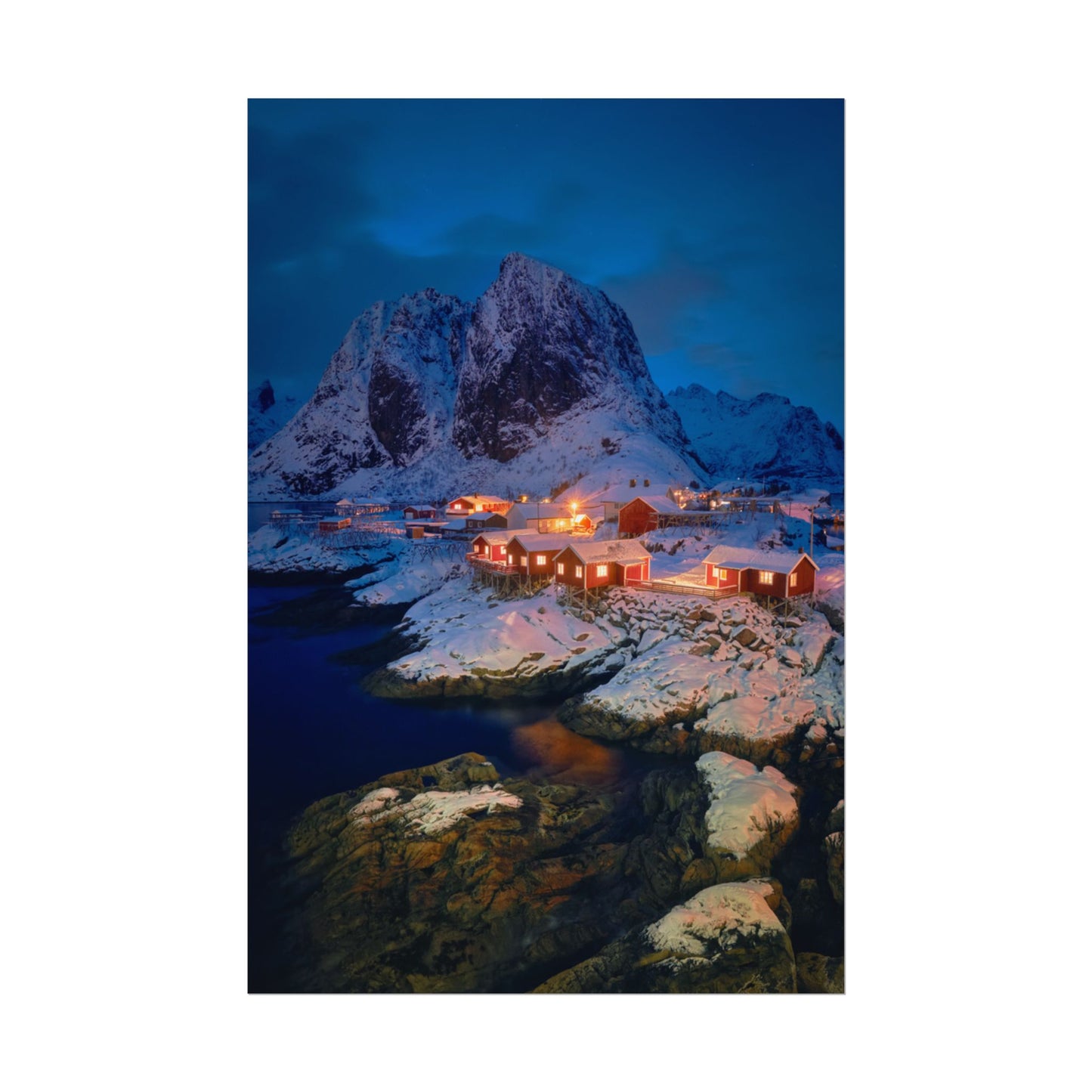 Snowy mountain landscape with illuminated buildings at night