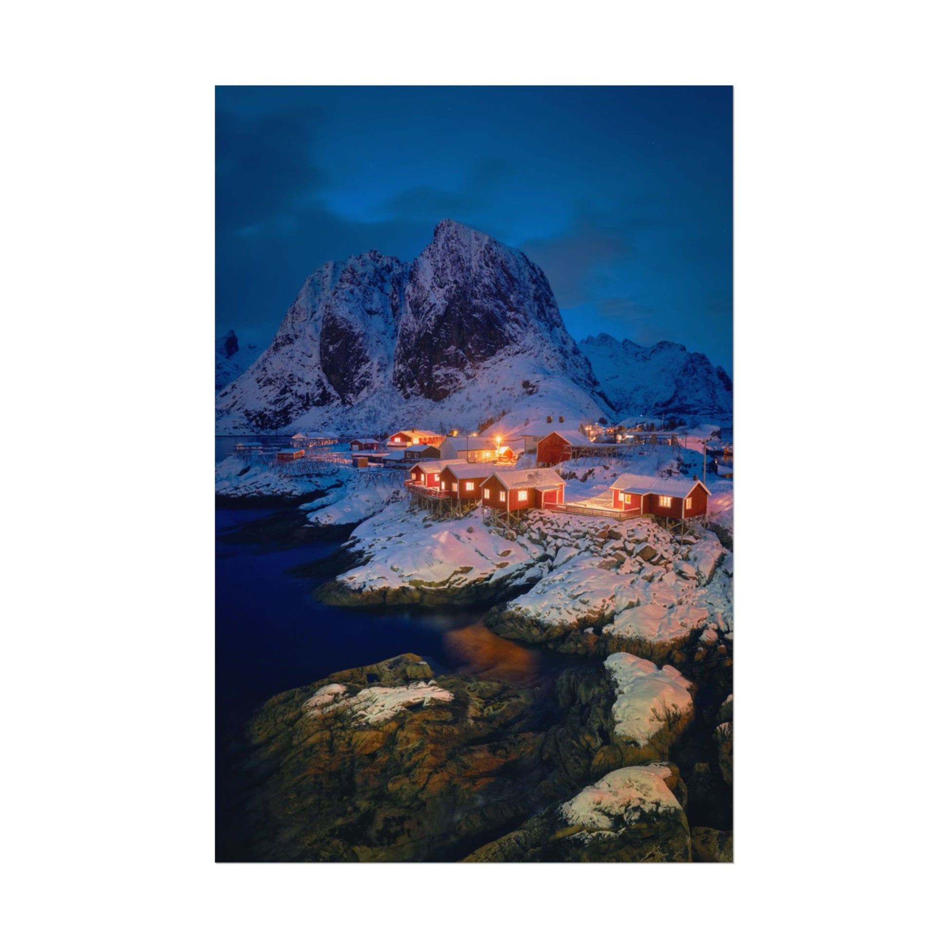 Snowy mountain landscape with illuminated buildings at night