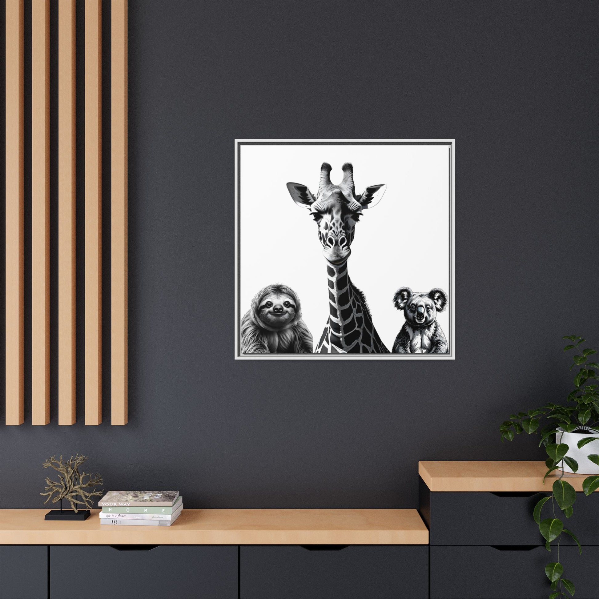 Framed artwork of a giraffe, sloth, and koala on a dark wall with wooden shelves.