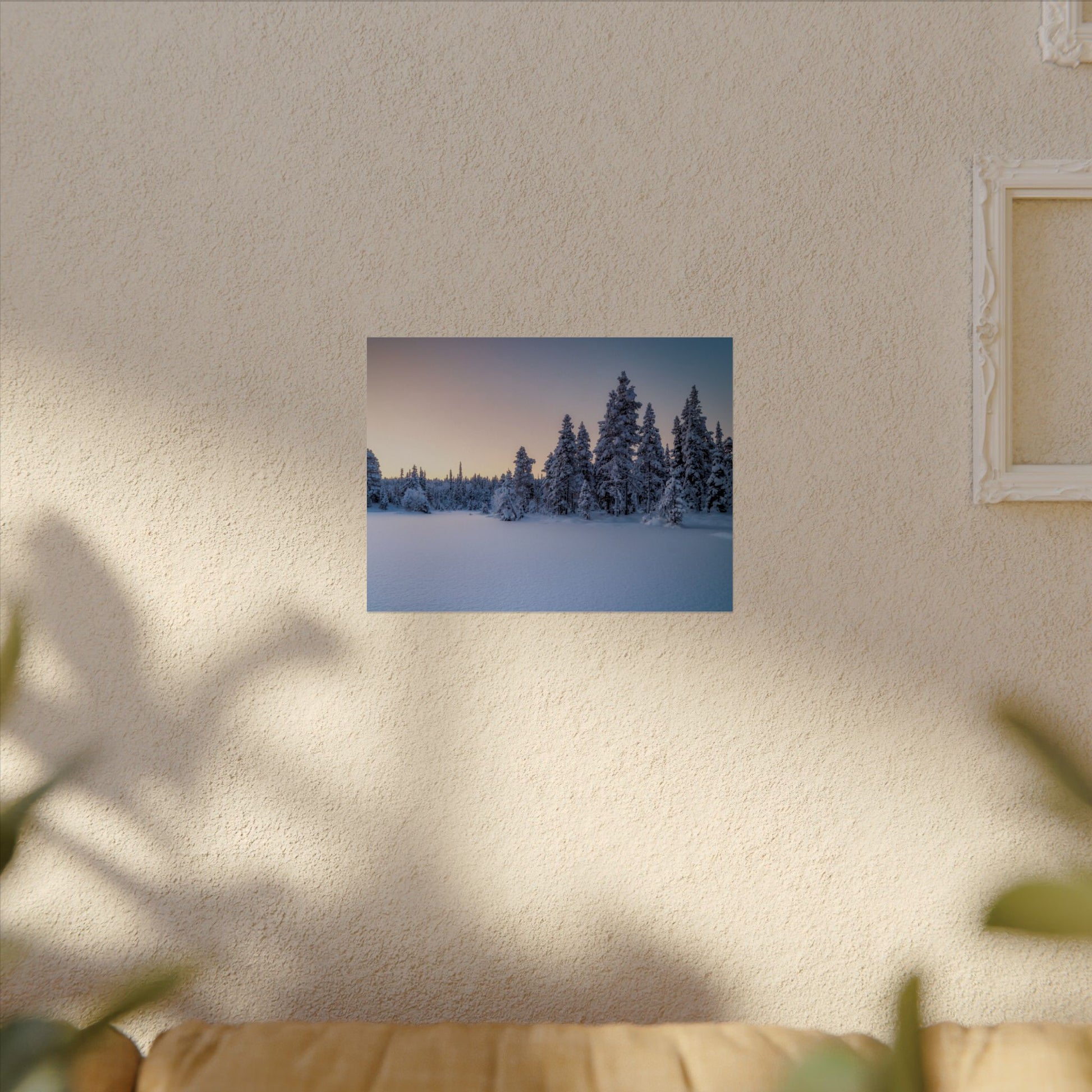 Framed photograph of a snowy landscape on a textured wall.