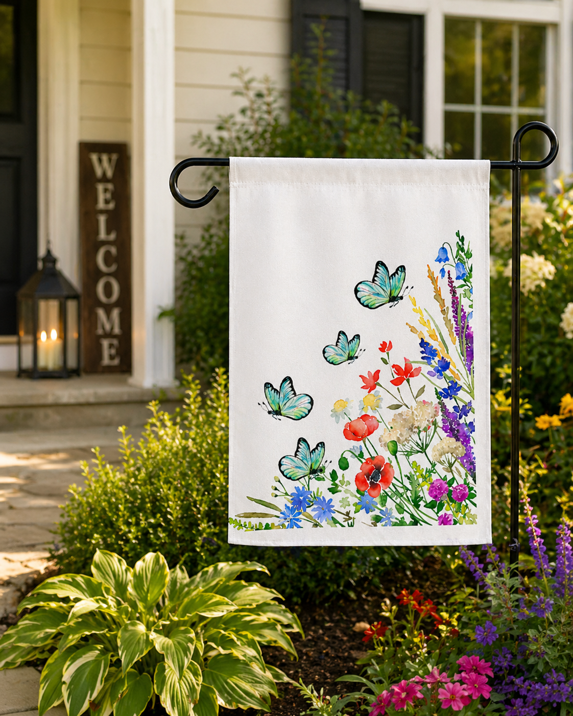 Garden flag with butterflies and flowers on a flagpole in front of a house with a 'Welcome' sign.
