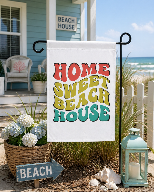 Decorative garden flag with 'Home Sweet Beach House' text in a beach setting.
