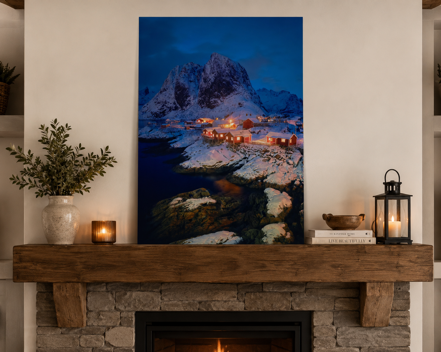 Framed artwork of a mountain village over a fireplace with candles and decor.
