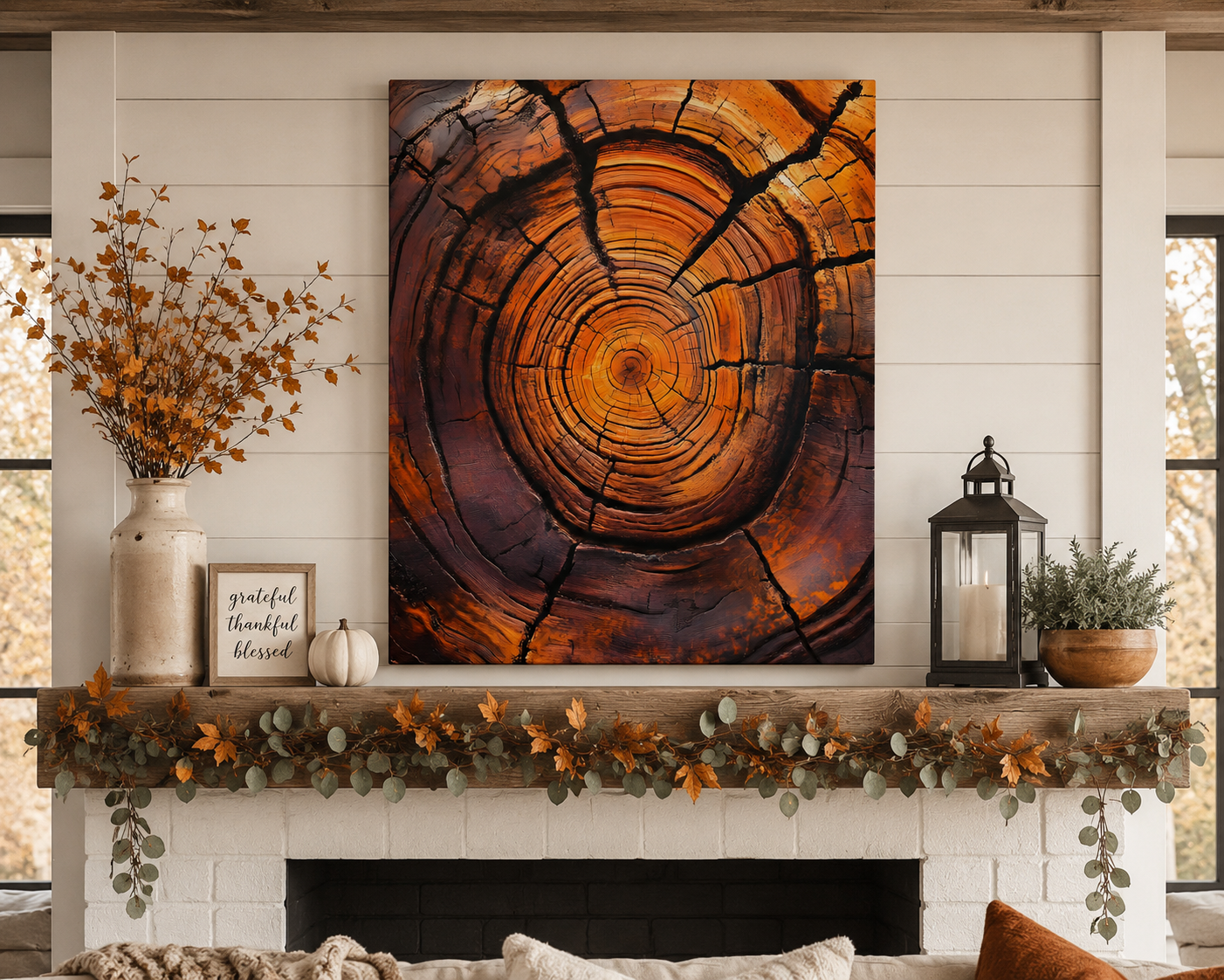 Decorative fireplace mantel with a large wooden ring art piece, candles, and pumpkins.